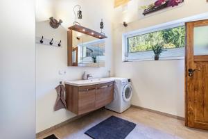 a laundry room with a sink and a washing machine at Ferienwohnung Petra Top 3 in Kössen +14 photos