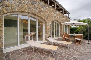 a patio with two chairs and an umbrella at Loggia Oliveto in Casanova Lerrore