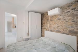 a bedroom with a bed and a stone wall at Loggia Oliveto in Casanova Lerrore