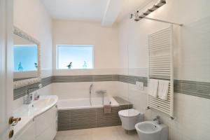 a bathroom with a tub and a toilet and a sink at Loggia Oliveto in Casanova Lerrore +16 photos