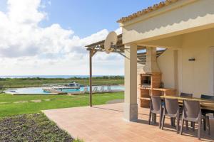 a patio with a table and chairs and a boat at Paraiso da Serva - Flor do Rosto 1 in Odemira