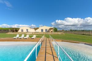 a swimming pool with lounge chairs and a house at Paraiso da Serva - Flor do Rosto 1 in Odemira