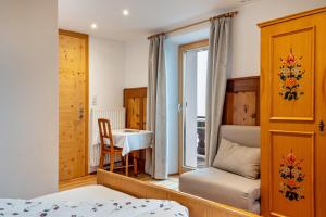 ein Schlafzimmer mit einem Bett, einem Tisch und einem Stuhl in der Unterkunft Grotthof in Deutschnofen