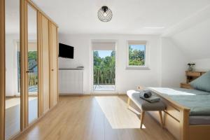 a white room with a bed and a desk and windows at Ferienhaus Donauliebe in Vohburg an der Donau