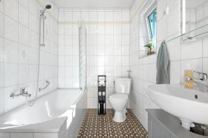 a bathroom with a tub and a toilet and a sink at Ferienhaus Donauliebe in Vohburg an der Donau +18 photos