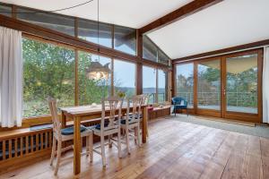 a dining room with a table and chairs and windows at Atelierwohnung Hof Kranichmoor in Horst