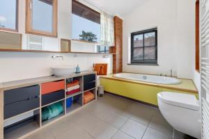a bathroom with a tub and a sink and a toilet at Atelierwohnung Hof Kranichmoor in Horst +21 photos