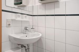 a bathroom with a sink and white tiled walls at Ferienhaus Kitzklause in Walkendorf +23 photos