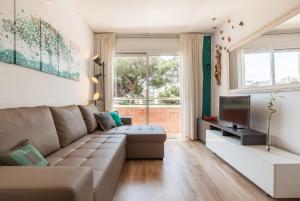 a living room with a couch and a television at Fada Lloret in Lloret de Mar