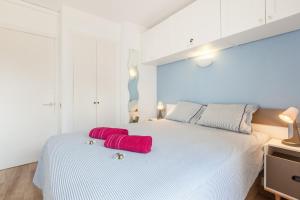 a white bed with two red pillows on it at Fada Lloret in Lloret de Mar +13 photos