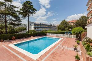 a swimming pool in a courtyard with a building in the background at Fada Lloret in Lloret de Mar
