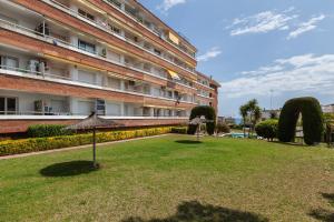 a park in front of a building with an umbrella at Fada Lloret in Lloret de Mar