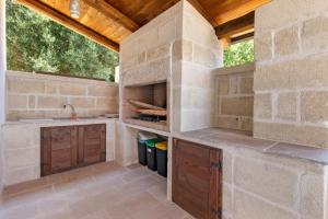 a stone kitchen with a counter and a sink at Trulli House in Putignano +57 photos