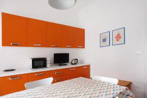 a kitchen with orange cabinets and a table with a microwave at Casa Caterina in Levanto