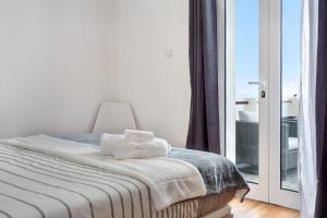 ein Schlafzimmer mit einem Bett, auf dem zwei Handtücher liegen in der Unterkunft Simão House in Calheta