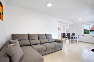 ein Wohnzimmer mit Sofa und ein Esszimmer in der Unterkunft Simão House in Calheta