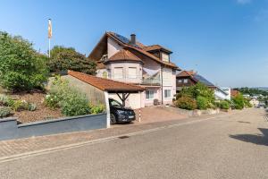 a house with a car parked on the side of a street at Ferienwohnung 'Kraichgau-Nest' in Reichartshausen