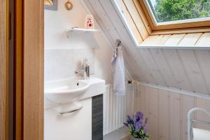 a tiny bathroom with a sink and a window at Ferienwohnung Simonsen in Rabenkirchen-Faulück +14 photos
