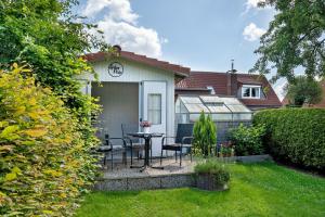 a house with a table and chairs in the backyard at Ferienwohnung Simonsen in Rabenkirchen-Faulück