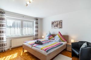 a bedroom with a bed and a chair at Ferienwohnung 'Kraichgau-Nest' in Reichartshausen