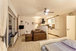 a living room with a couch and a ceiling fan at Ferienwohnung Bergidyll in Schmallenberg