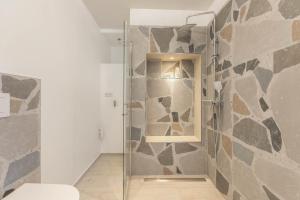 a bathroom with a shower with a stone wall at Wohnung Deluxe in Heide