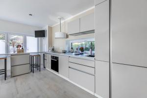 a white kitchen with white cabinets and a counter at Wohnung Deluxe in Heide +12 photos