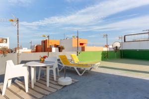 a patio with two chairs and a table on a roof at Charro Room in Corralejo