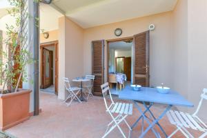 a patio with a blue table and chairs at Appartamento Thomas in Capoliveri