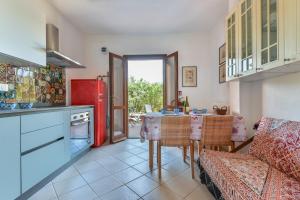 a kitchen with a table and a red refrigerator at Appartamento Thomas in Capoliveri +16 photos