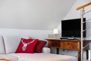 a living room with a couch and a tv at Ferienwohnung Hirschsprung Saig in Lenzkirch