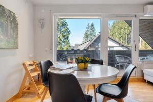 a dining room with a table and chairs and a large window at Ferienwohnung Hirschsprung Saig in Lenzkirch
