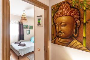 a room with a painting of a buddha on the wall at Charro Room in Corralejo