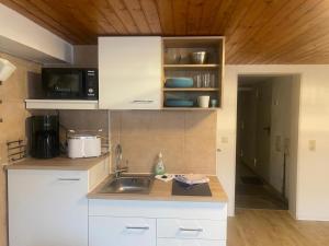 a small kitchen with a sink and a microwave at Fewo1 Am Edersee in Edertal