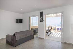 a living room with a couch and a balcony at Splendide Grand Appart Neuf in Albitreccia