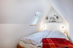 a bedroom with a bed with a blanket and a window at Inselliebe in Pellworm