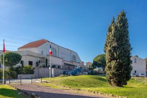 a large white building with a tree in front of it at Joli Chalet en bois mésange bleu in Roquebrune-sur-Argens