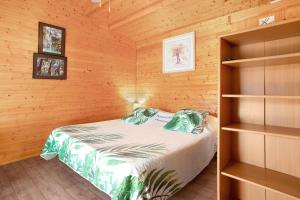a bedroom with a bed in a wooden cabin at Joli Chalet en bois mésange bleu in Roquebrune-sur-Argens