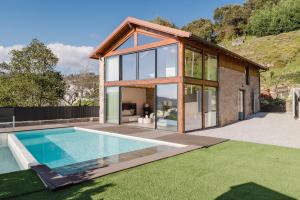 a house with a swimming pool in the yard at Dunas e Abraços in Braga