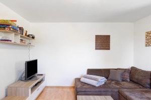 a living room with a couch and a tv at Kreuzbergblick Bayerischer Wald in Hohenau