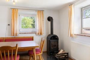 a wood stove in a dining room with a table at Kreuzbergblick Bayerischer Wald in Hohenau