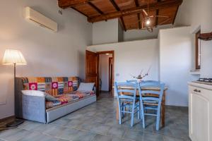 a living room with a couch and a table and chairs at La Svolta - Aria in Manciano