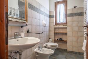 a bathroom with a sink and a toilet and a mirror at La Svolta - Aria in Manciano