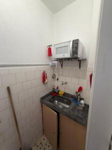 a small kitchen with a sink and a microwave at Apartamento Centro Imperial de Petrópolis in Petrópolis
