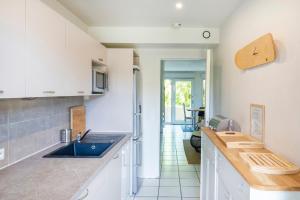 a kitchen with white cabinets and a blue sink at Dune Lodge 1- Capbreton Hossegor - in Capbreton