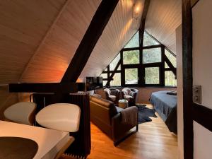 a attic bedroom with a bed and a couch at Landhaus Bornemann in Diemelsee