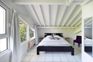 a bedroom with a bed in a room with windows at Dune Lodge 1- Capbreton Hossegor - in Capbreton
