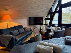 a living room with a couch and a tv at Landhaus Bornemann in Diemelsee
