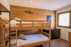 a bedroom with two bunk beds in a cabin at Chalet Lova in Valloire