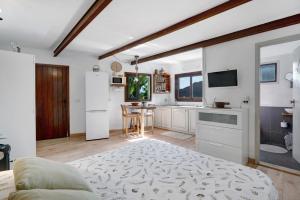 a kitchen with white cabinets and a table and a refrigerator at Casa Tajaraste 1 in Hermigua